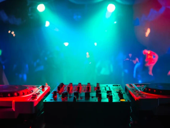 looking over a set of turntables at a club scene