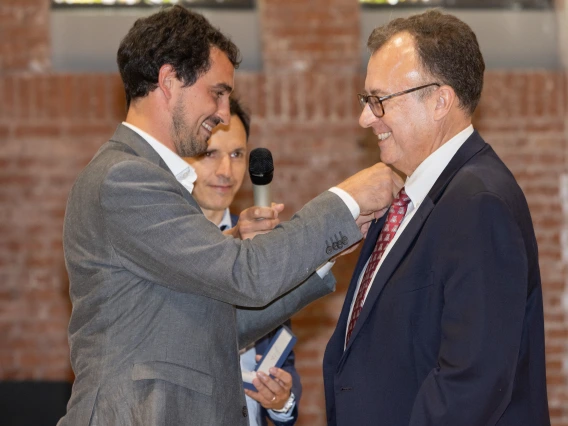Consul of France in Los Angeles, the Honorable Adrien Frier, pins the Palmes Académiques honor on Dorrance Dean A-P Durand.