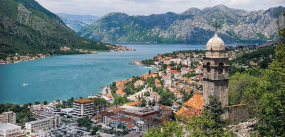 Beautiful view of an ancient town by a river near the mountains