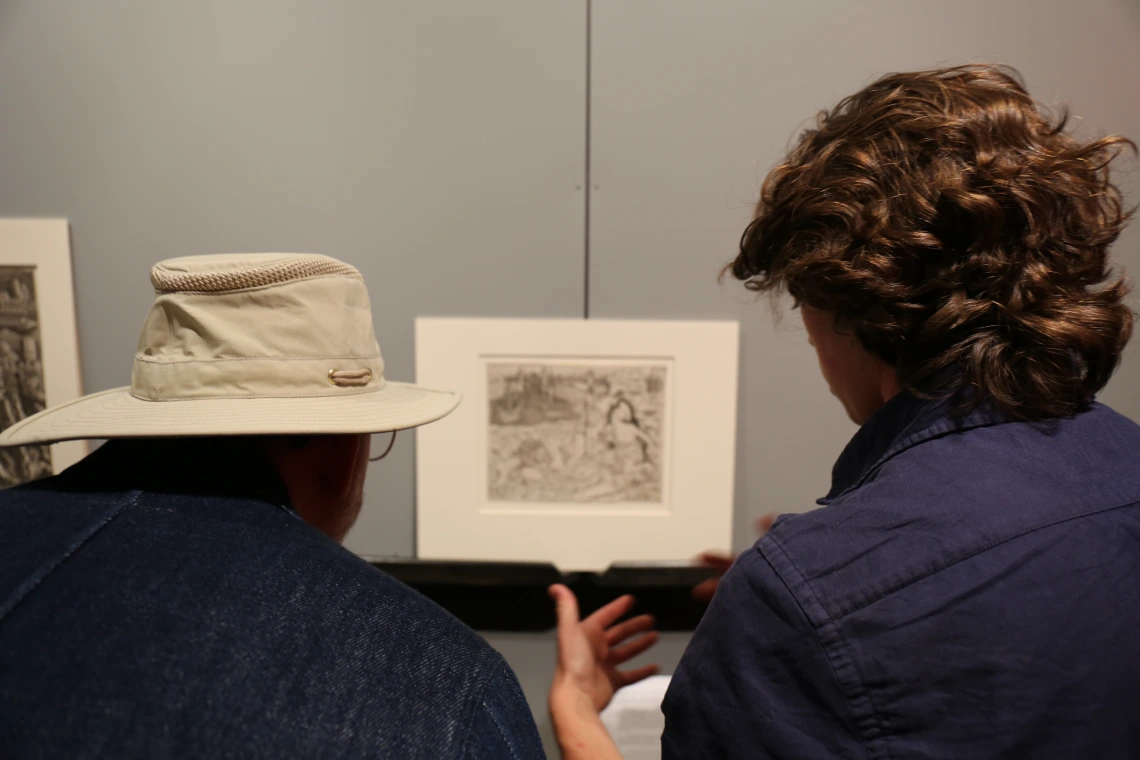 Adrien Abel (right) discusses his print with COH Associate Dean Ken McAllister.